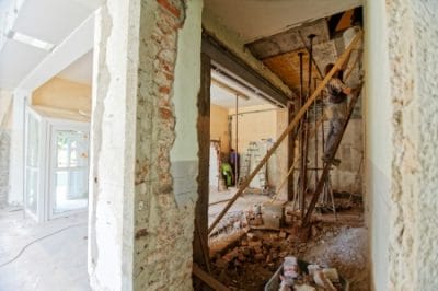 Renovierung im Inneren eines Hauses: Eine Person steht auf einer Leiter.