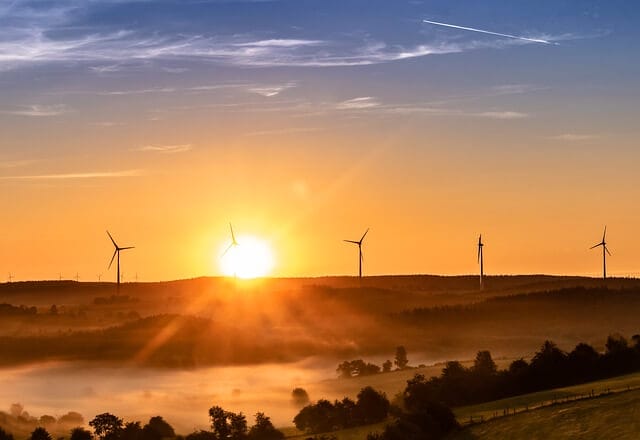 Windräder auf einer Anhöhe vor Sonnenaufgang