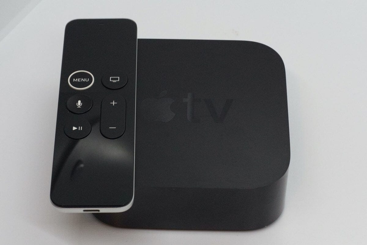 Draufsicht: schwarzer Apple TV inkl. Fernbedienung.