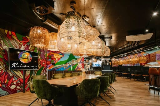 Bunte Tapeten, riesige Lampen und ein großer Esstisch sind im Gemeinschaftsraum dieses Boardinghouses zu sehen. 