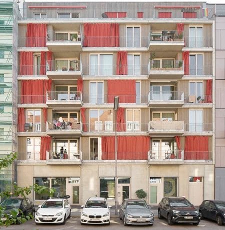 Straßenansicht des Ausbauhauses in Berlin-Südkreuz. Das Gebäude ist von einer Holzfassade und bodentiefen Fenstern geprägt.