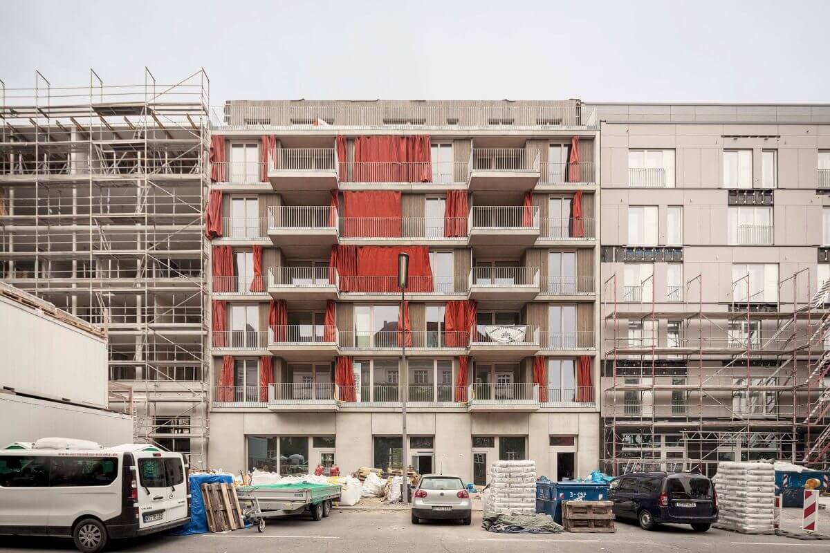 Straßenansicht des Ausbauhauses in Berlin-Südkreuz. Das Gebäude ist von einer Holzfassade und bodentiefen Fenstern geprägt.