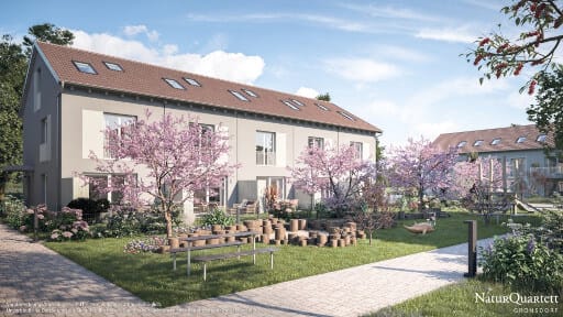 Eine Reihenhaussiedlung mit blühenden Kirschbäumen und Grünflächen in der Mitte.