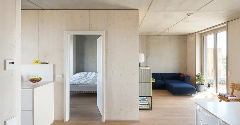 Innenansicht des Ausbauhauses, geprägt von Holzwänden und Betondecken.