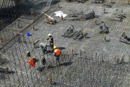 Baustelle mit drei Bauarbeitern. Würde das Schneller Bauen Gesetz in Kraft treten, könnte es in Berlin in Zukunft noch mehr Baustellen geben.