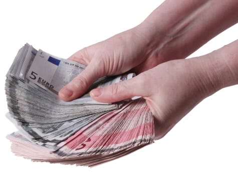 Hände halten Geldscheine.