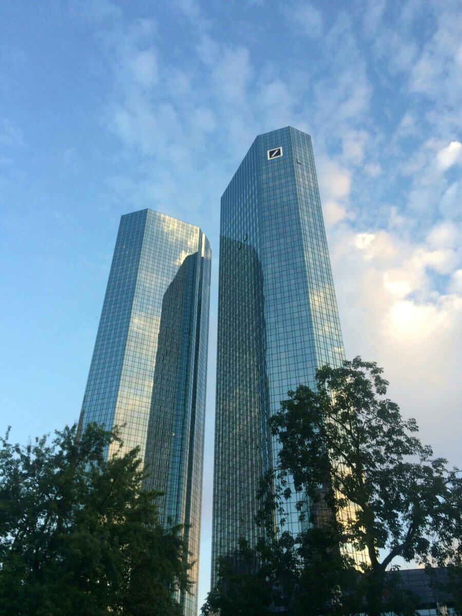 Das Deutsche-Bank-Hochhaus prägt Frankfurts Skyline: Zwei hohe, spiegelnde Glasgebäude ragen in den Himmel.