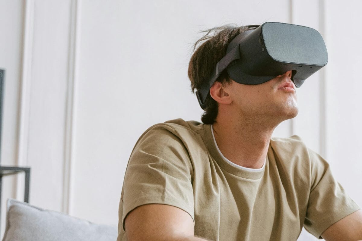 Mann sitzt auf dem Sofa und trägt eine VR-Brille