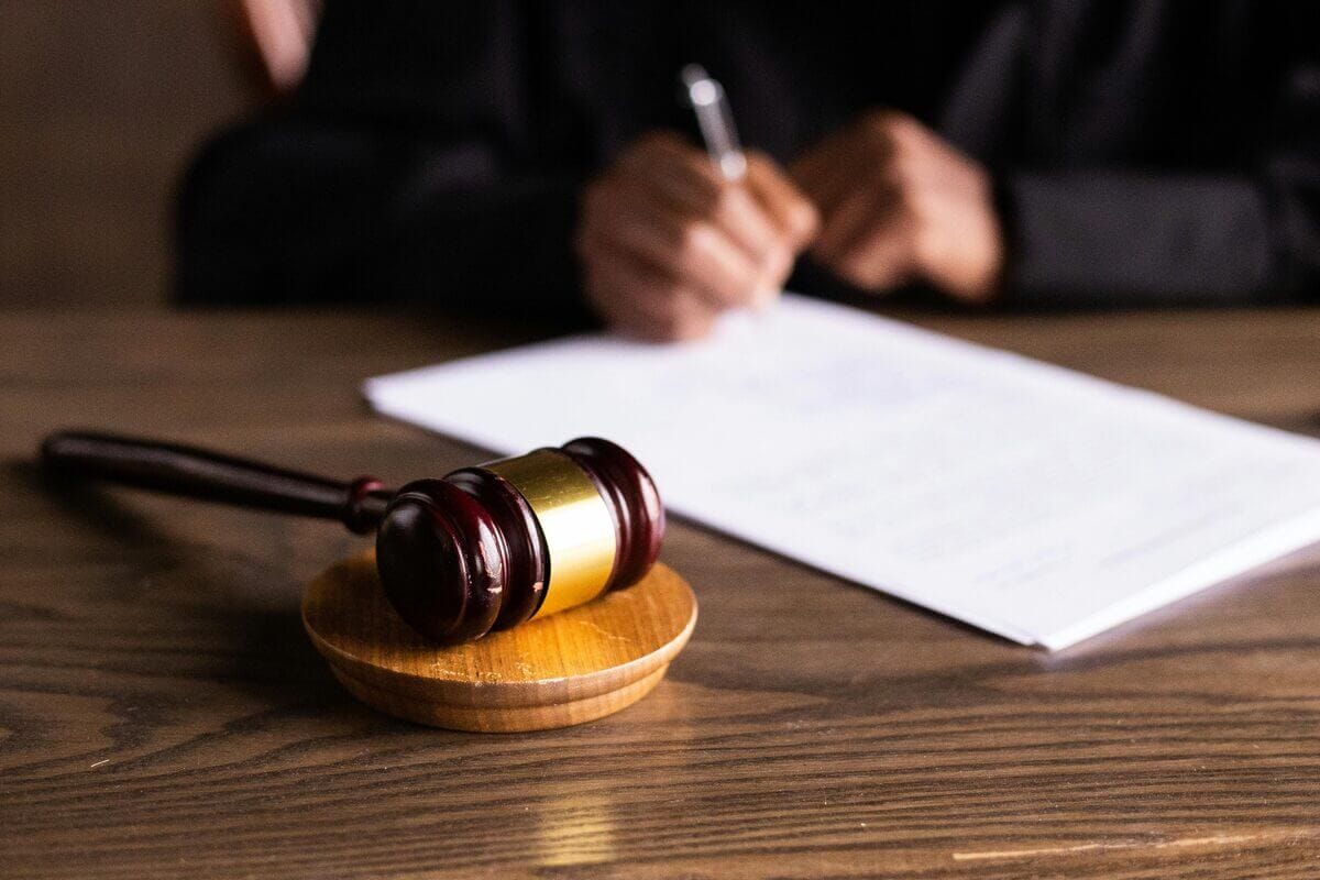 Richter unterzeichnet Dokument – daneben liegt Richterhammer.jpg