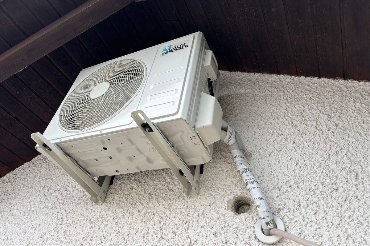 Weiße Außeneinheit einer Split-Klimaanlage an der Wand montiert.